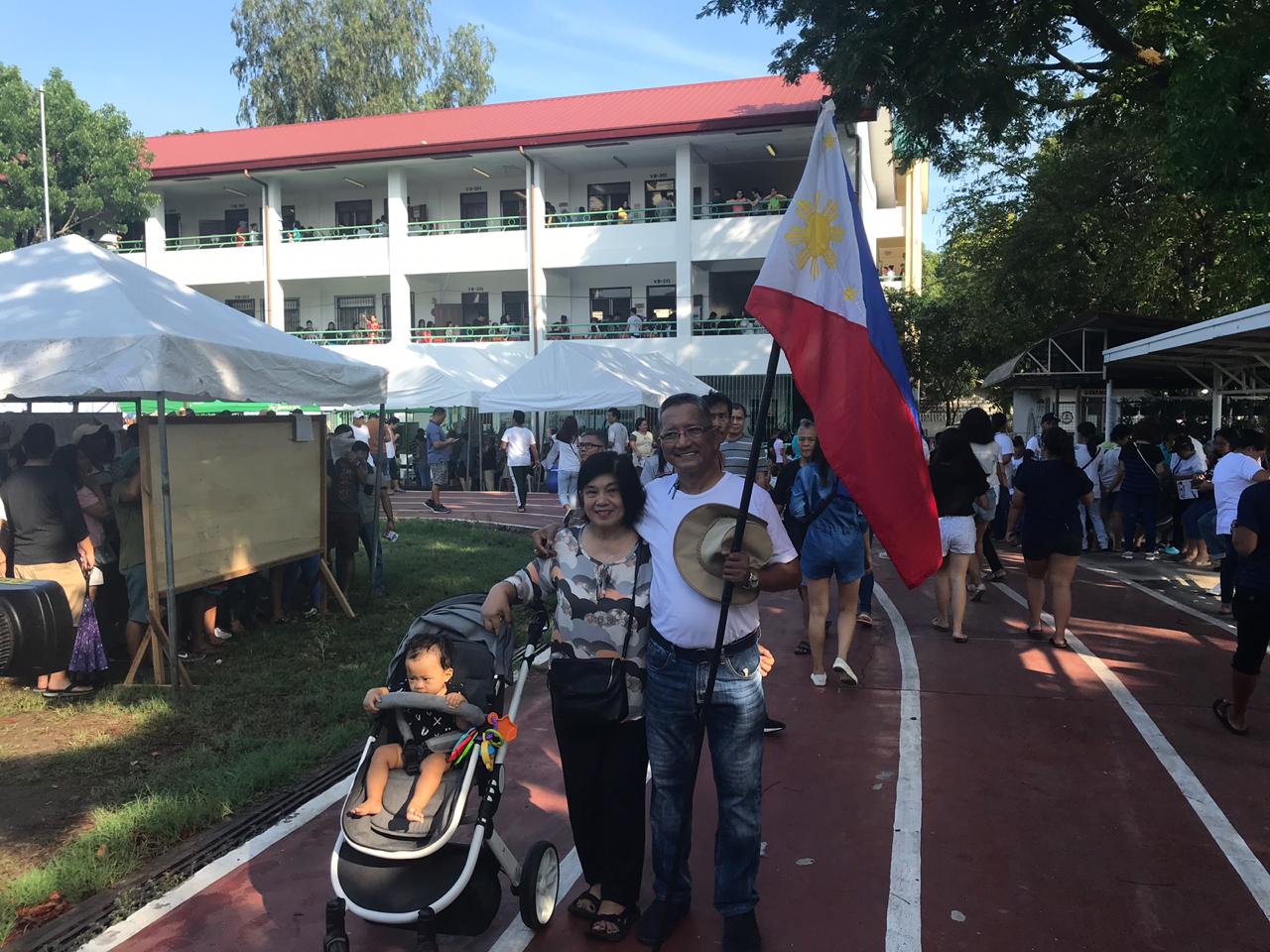 Man brings Philippine flag to polling precinct, votes for opposition senators